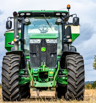 green and black tractor on brown grass field during daytime