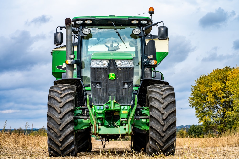 Trattore verde e nero sul campo di erba marrone durante il giorno