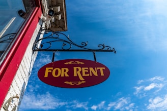 A professional "For Rent" sign against a clear blue sky, representing property owner rights and lega