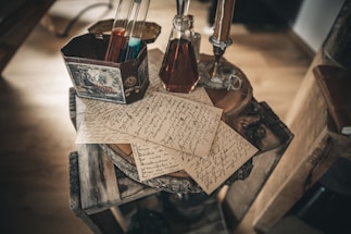 A rustic wooden table with a bottle of Nanixhe mezcal and a handwritten letter beside it.