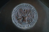silver round coin on black textile
