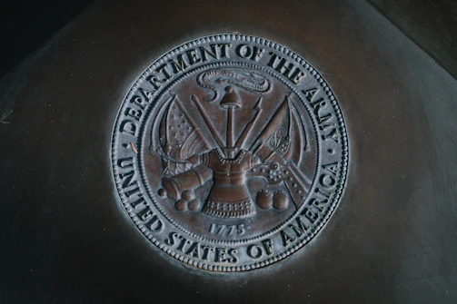 silver round coin on black textile