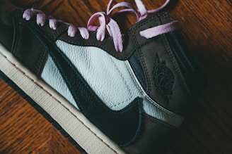 A candid black-and-white photo of a female Nike designer sketching shoe concepts in a lively studio filled with prototypes and fabric swatches.