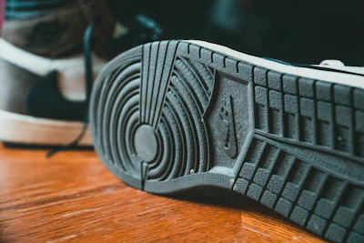 gray adidas shoe on brown wooden table