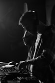 A close-up of a DJ wearing headphones and mixing music.
