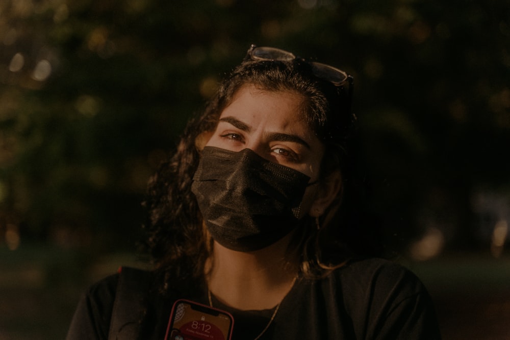 woman in black crew neck shirt wearing black mask