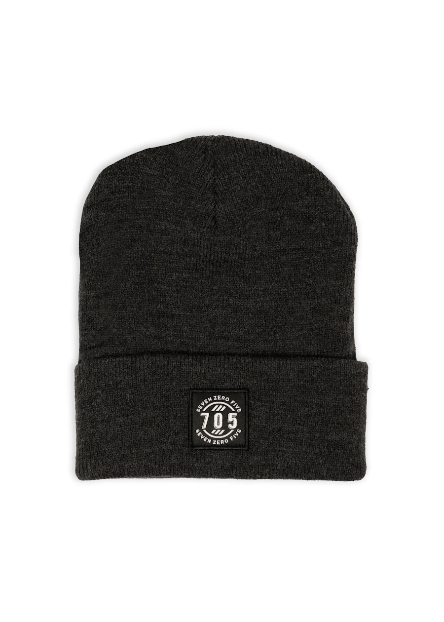 A folded charcoal knitted beanie with a small woven label