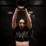 woman in black sports bra and panty holding black kettle bell