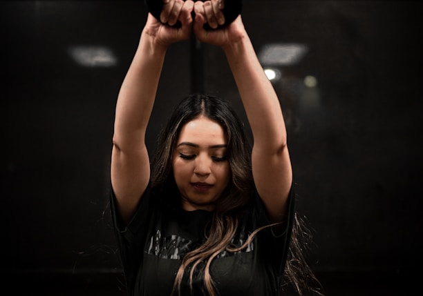 woman in black sports bra and panty holding black kettle bell