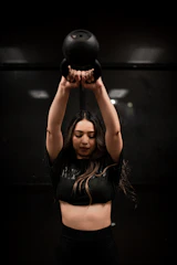 Athlete performing a controlled kettlebell swing in a bright studio.