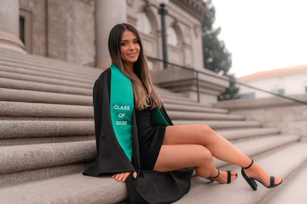 woman in black and green long sleeve dress sitting on stairs