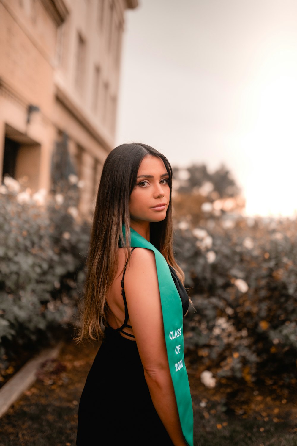 woman in black tank top standing near brown concrete building during daytime