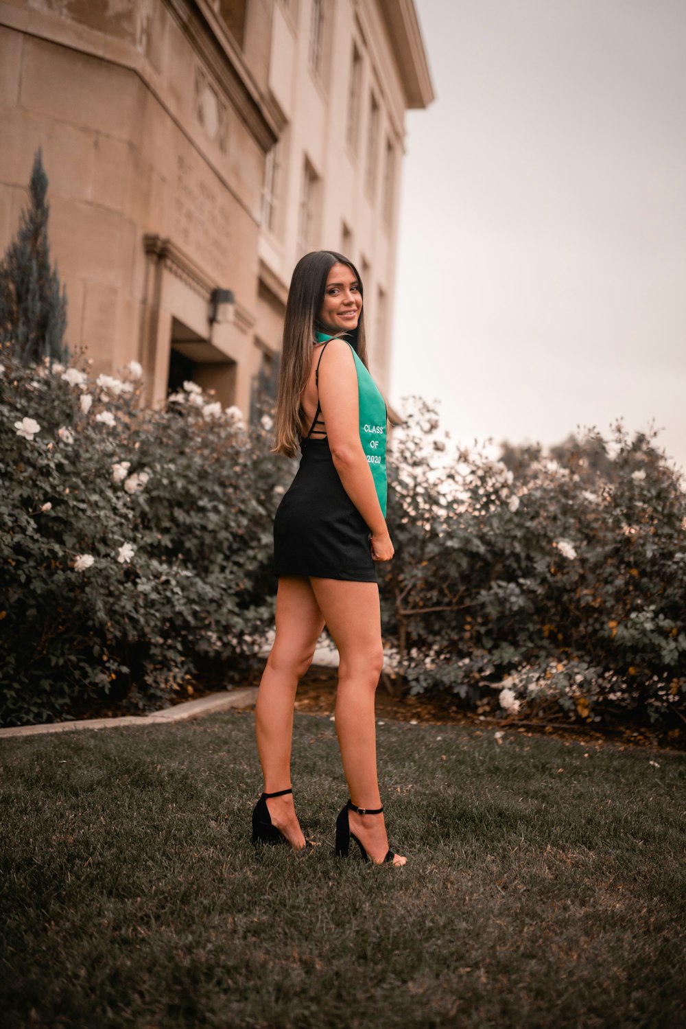 woman in blue tank top and black mini skirt standing on pathway