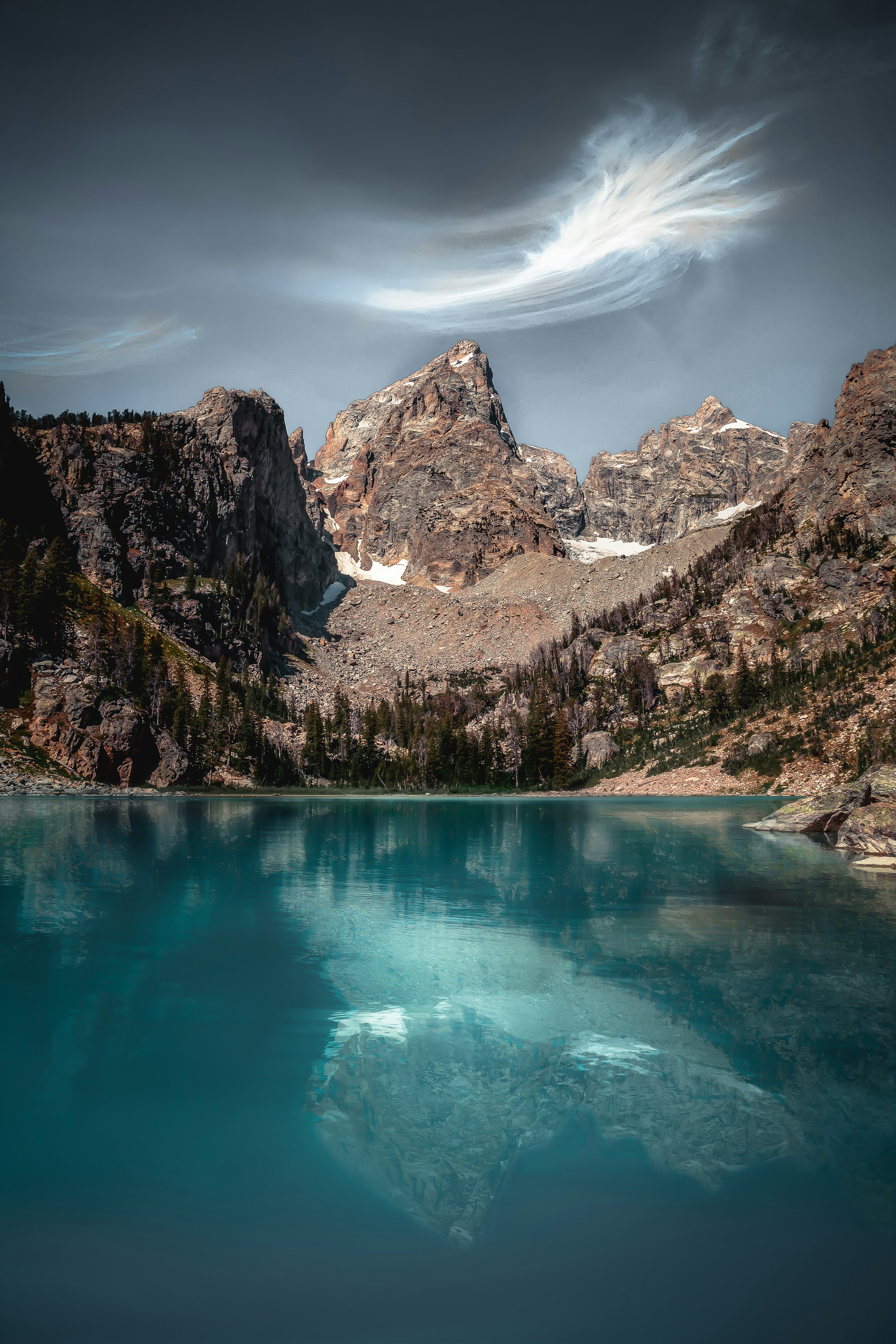 blue lake surrounded by brown and white mountains under blue sky during daytime