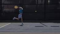 Dynamic action shot of a player lunging to defend a fast return.