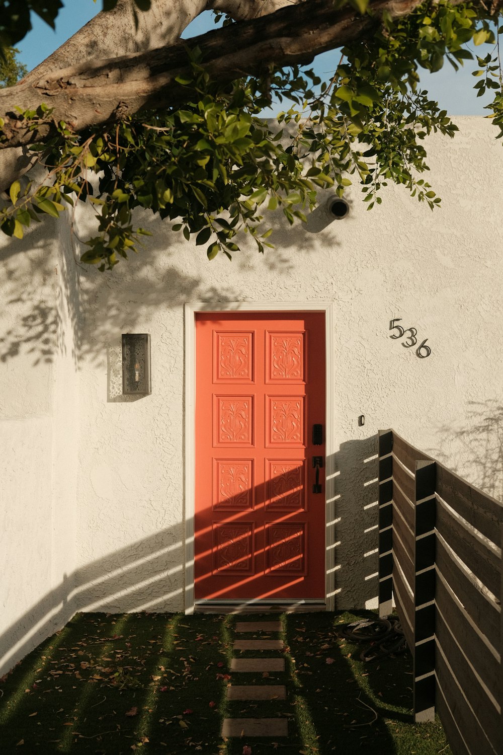 red wooden door on white concrete wall
