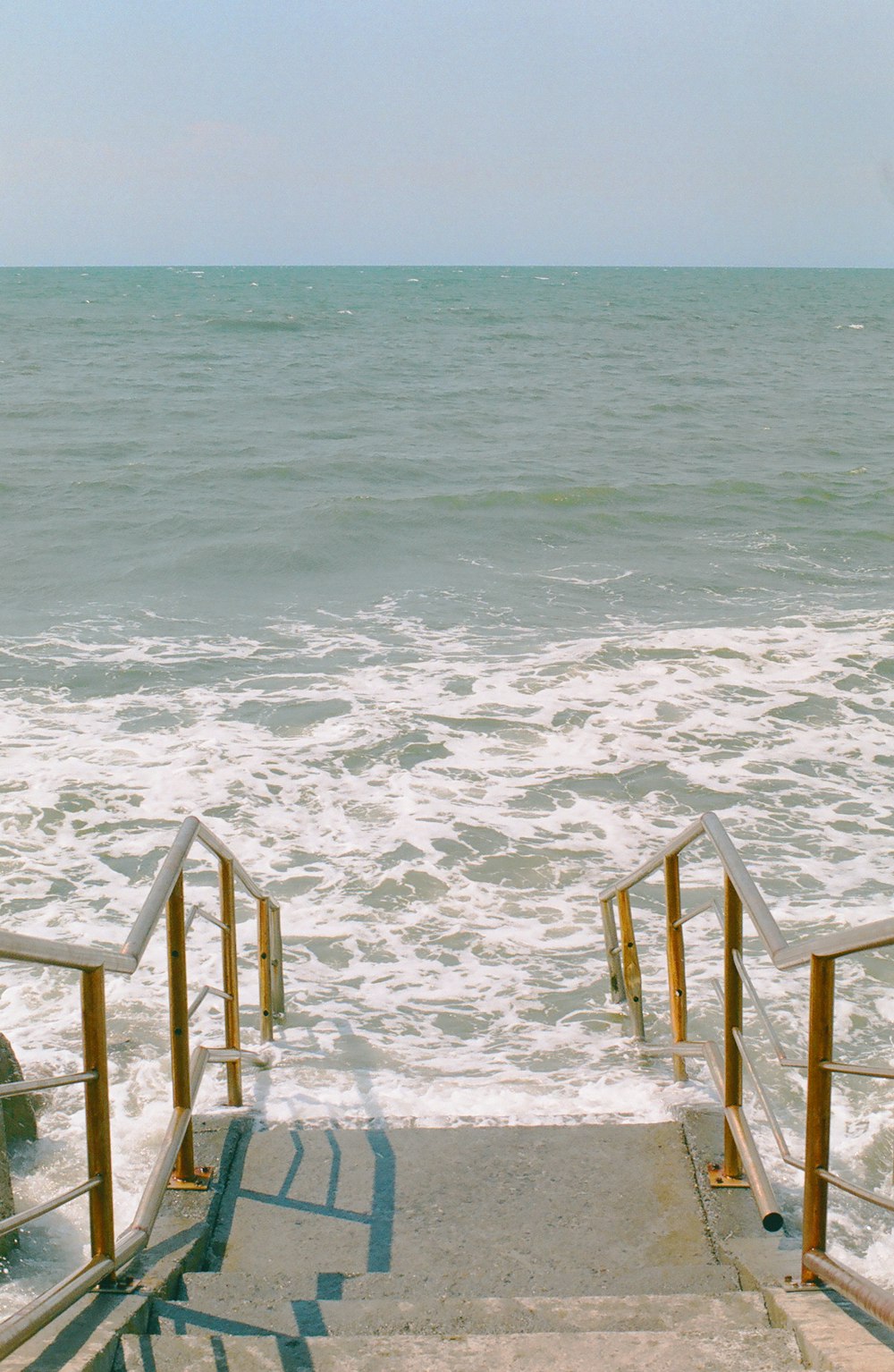 brown wooden fence on white sand beach during daytime