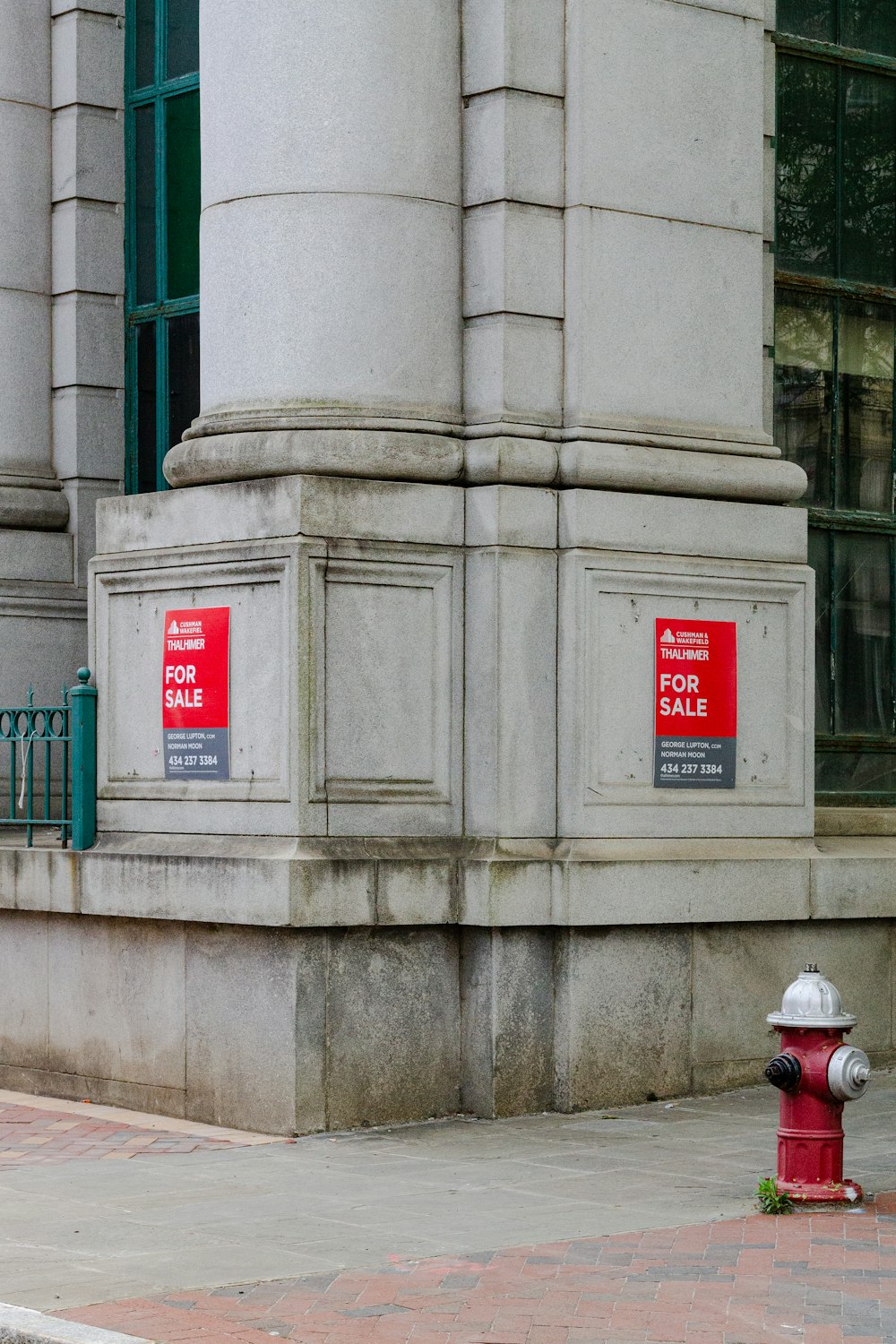 灰色のコンクリート壁の近くの赤い消火栓
