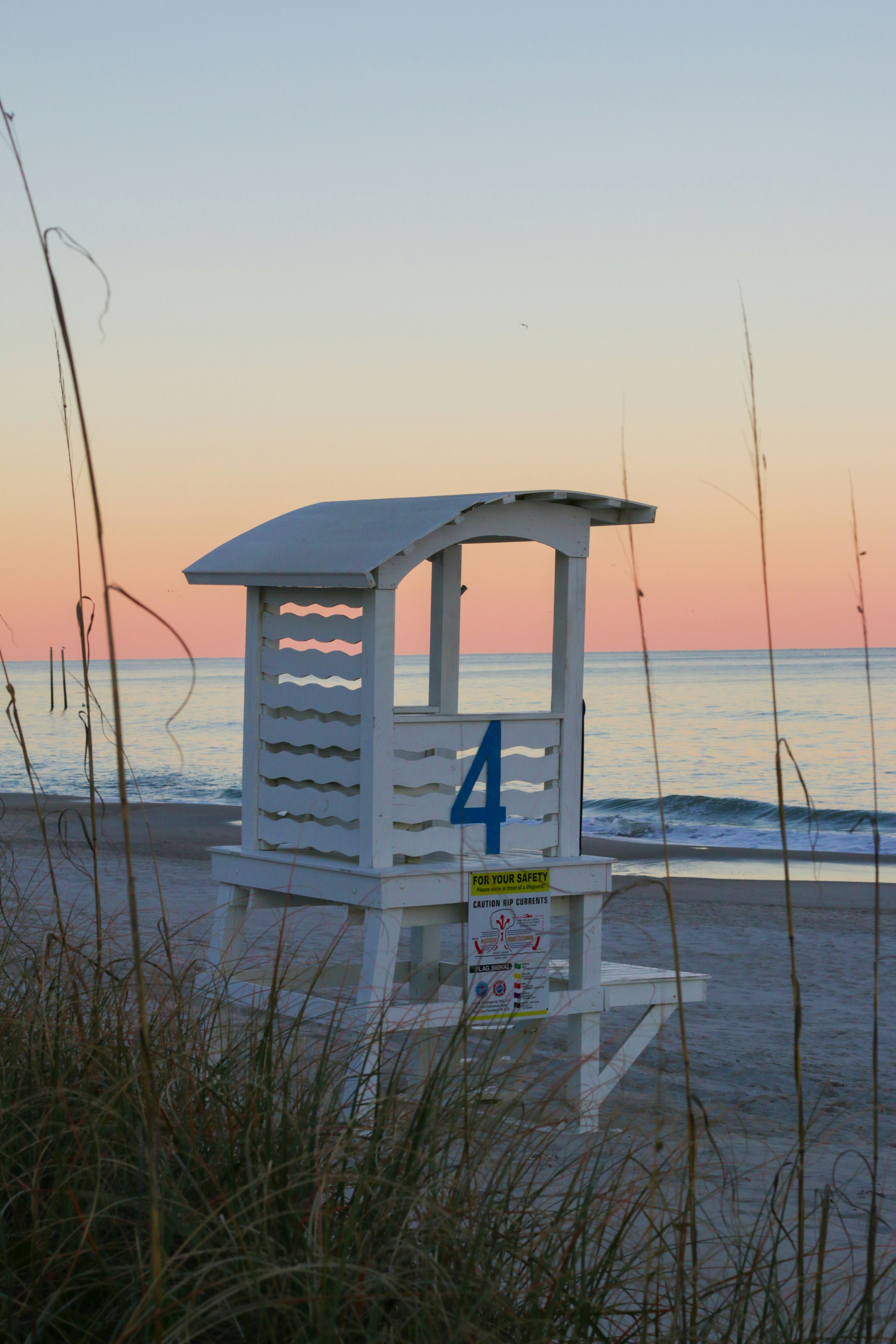 white wooden lifeguard tower near body of water during daytime