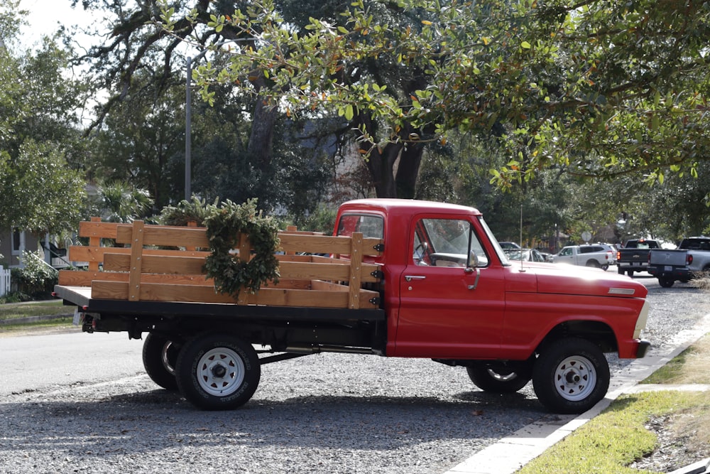 red single cab pickup truck parked near green trees during daytime