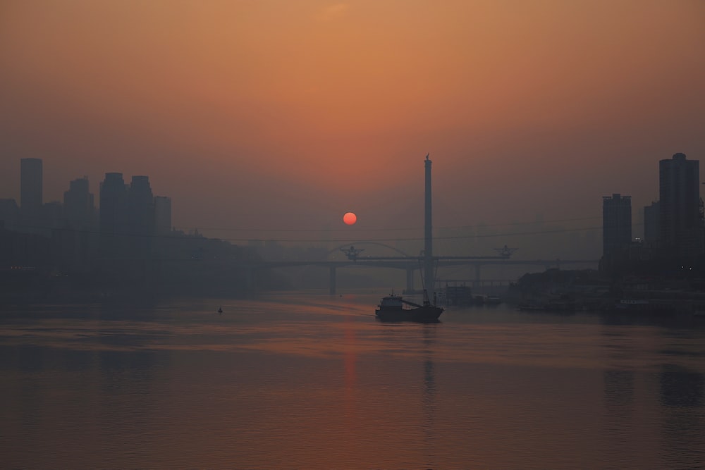 silhouette of boat on water during sunset