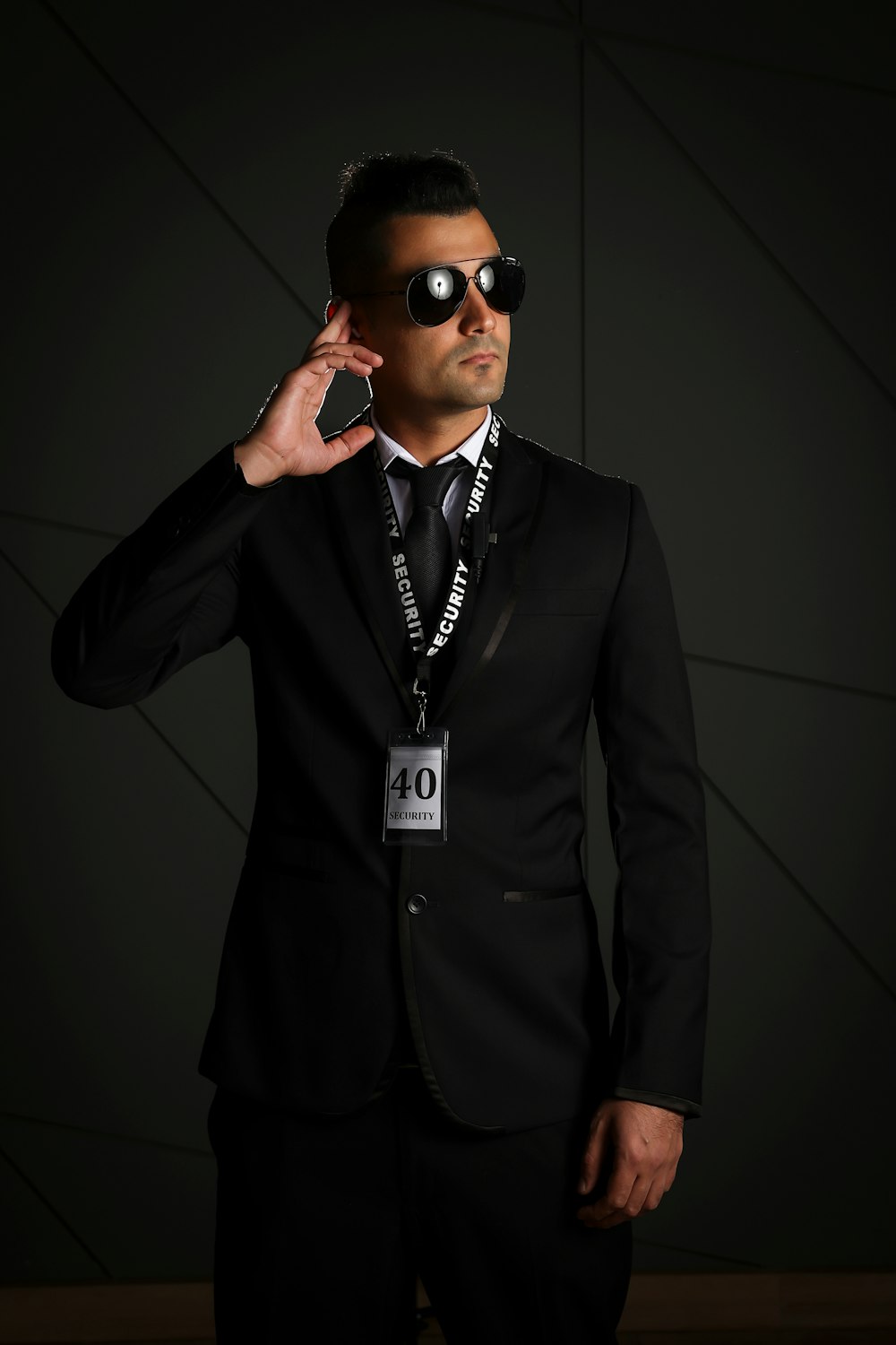 Homme en costume noir portant des lunettes de soleil noires