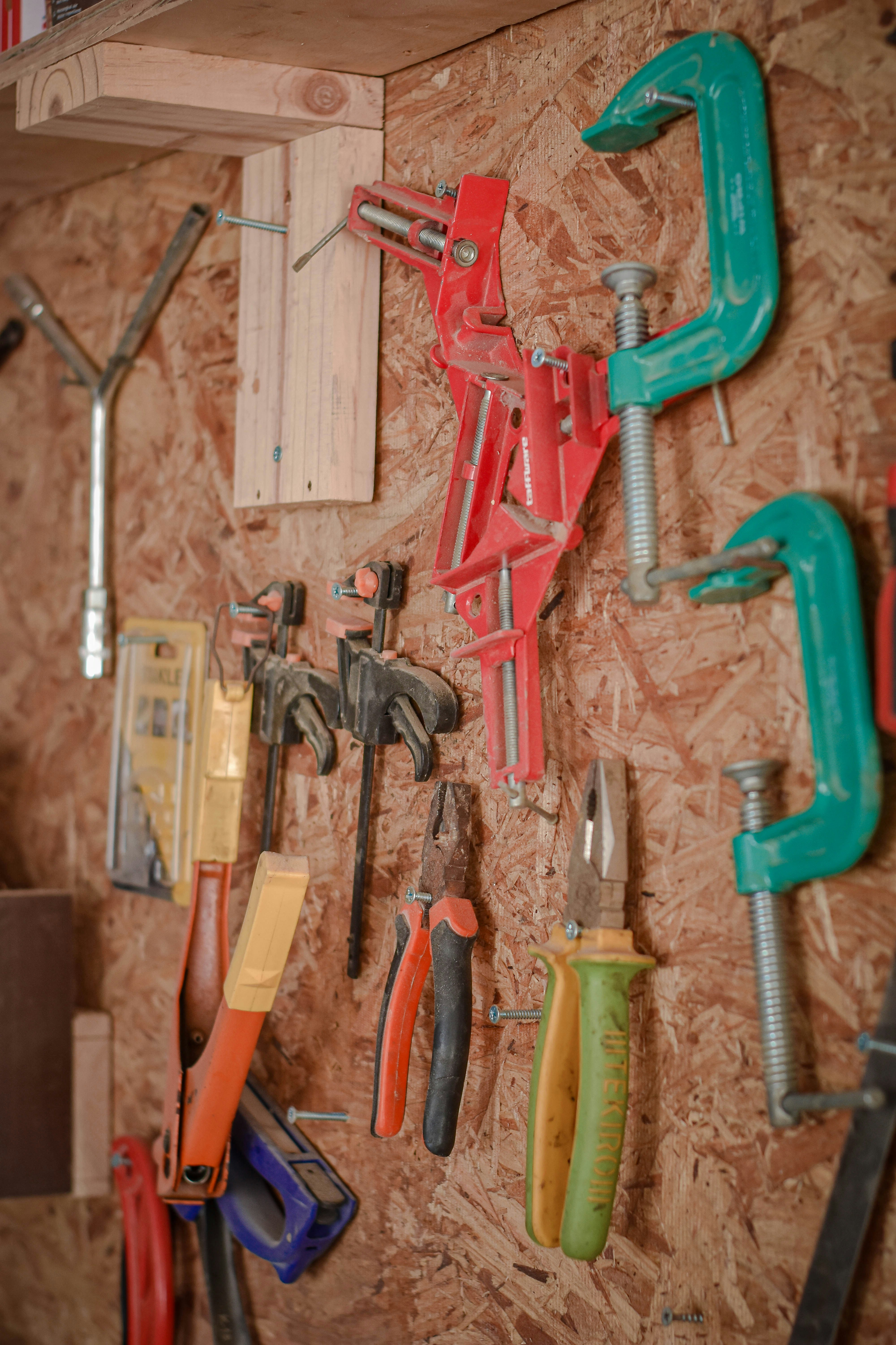 assorted hand tools on brown wooden wall
