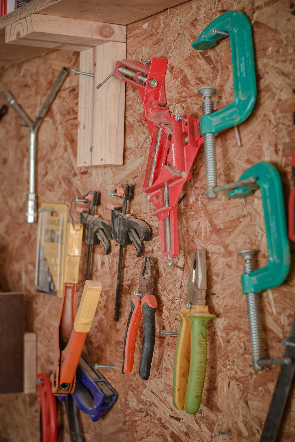 assorted hand tools on brown wooden wall