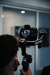 man holding black dslr camera