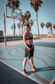 An athlete wearing Mrs. Marie by MM activewear, mid-motion on a basketball court lit with warm golden light.