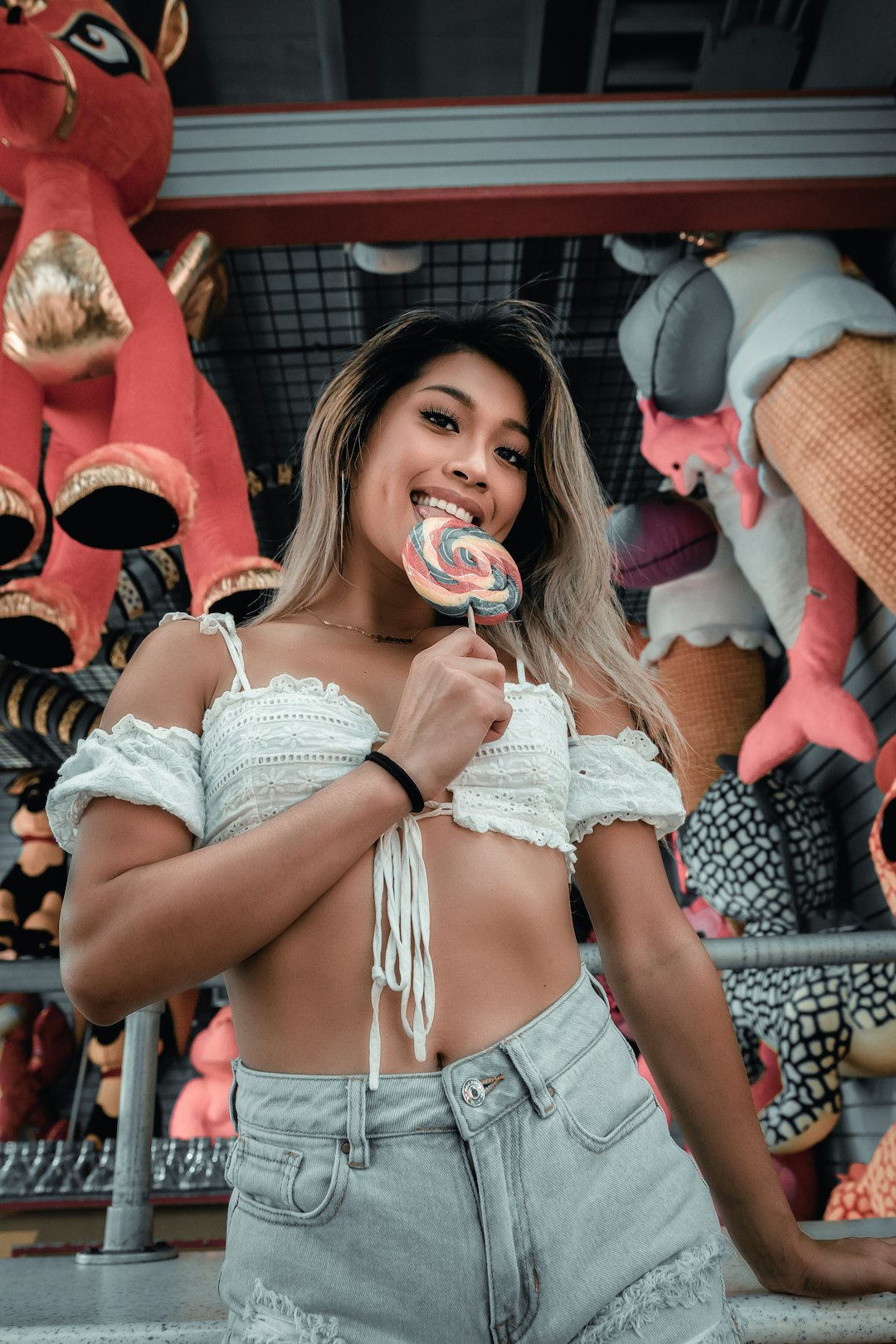 woman in blue denim shorts holding lollipop