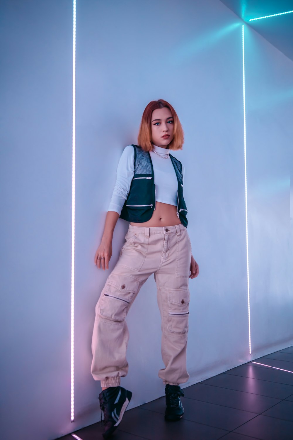 Mujer con camisa de manga larga azul y blanca y pantalón marrón