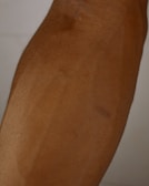 A close-up of a flawless tan on a model's arm.