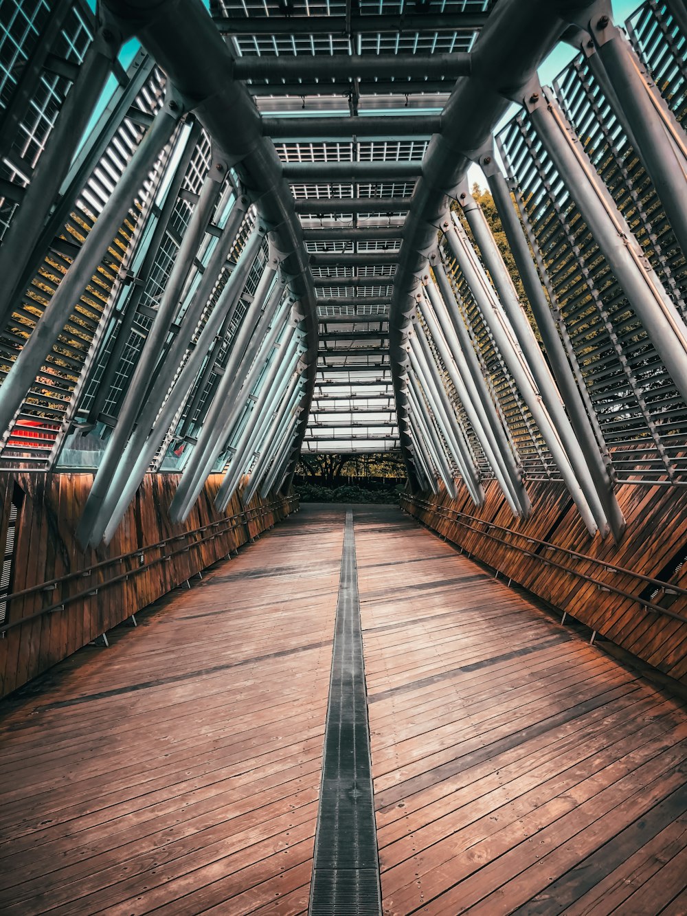 brown wooden hallway with gray metal railings