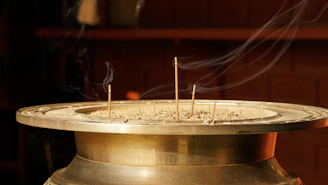 Traditional incense burning in a brass holder, surrounded by soft glowing light