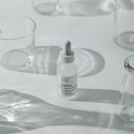 A clean, modern glassmorphism card featuring a variety of skincare products with soft shadows.