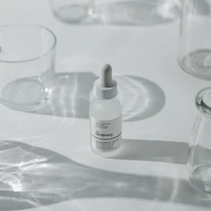 Elegant bottles of serums and oils arranged on a clean white surface with soft natural light.