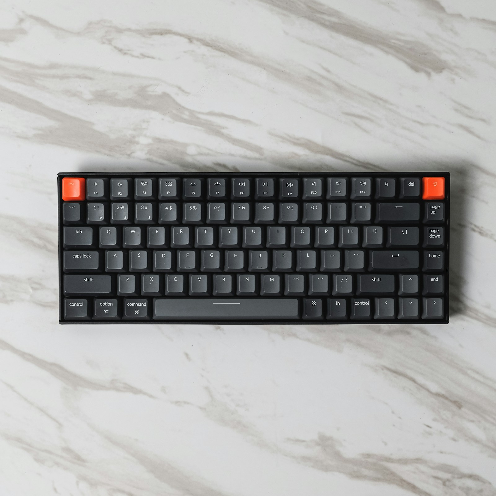 A mechanical keyboard on a desk with a cup of coffee, showing a clean typing setup