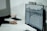A person working at a desk with a computer monitor displaying a detailed technical drawing or architectural blueprint. The background is blurred, focusing on the screen with the design.