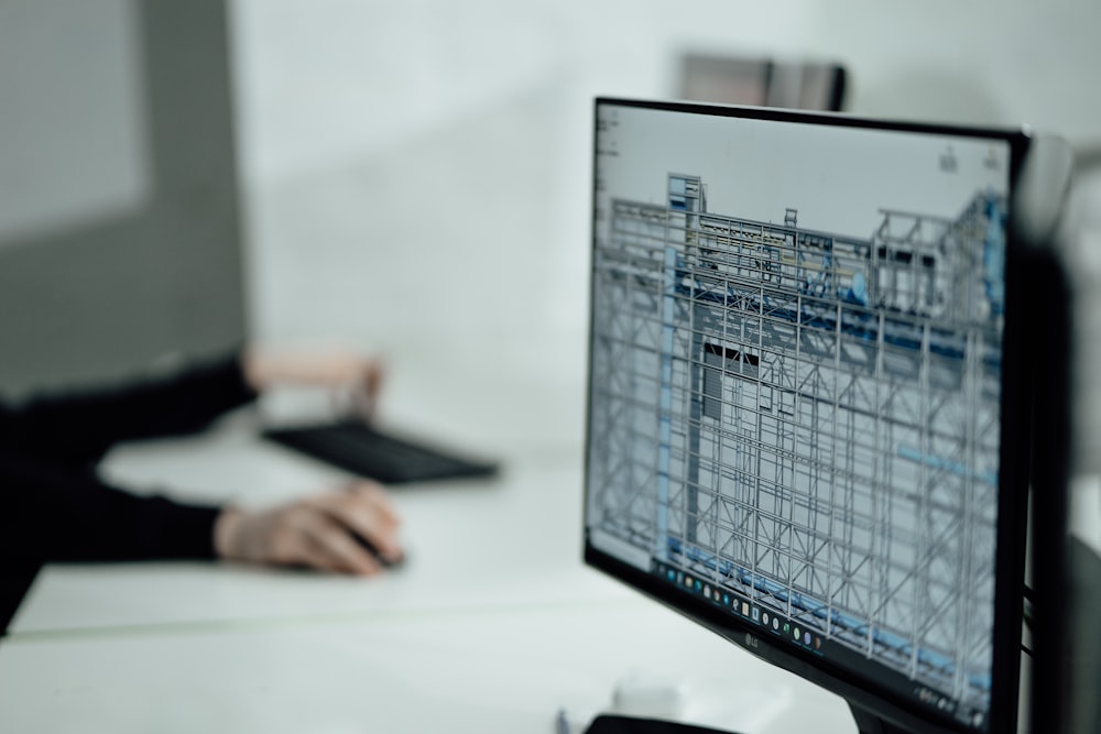 person using black laptop computer overlooking construction drawings