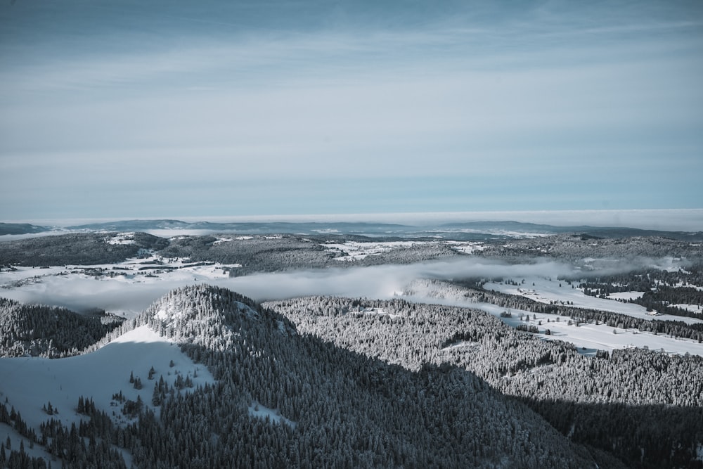 campo coberto de neve sob o céu azul durante o dia