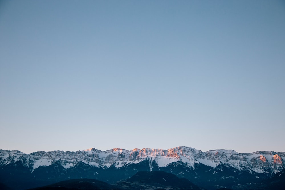 snow covered mountain under gray sky