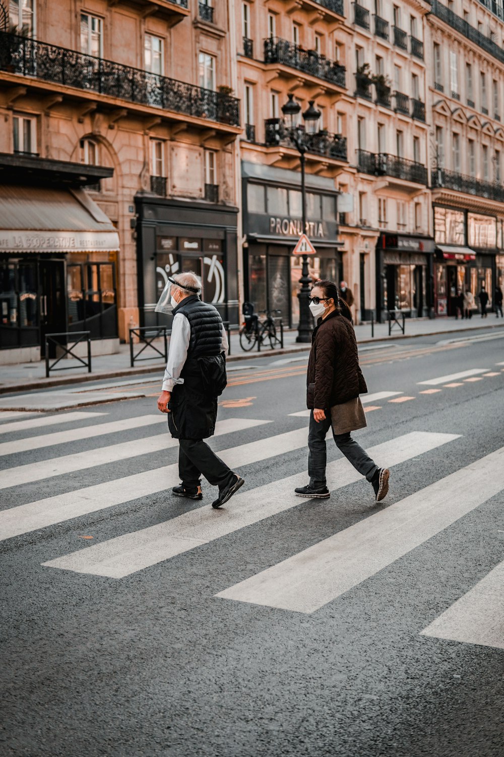 man in black coat walking on pedestrian lane during daytime