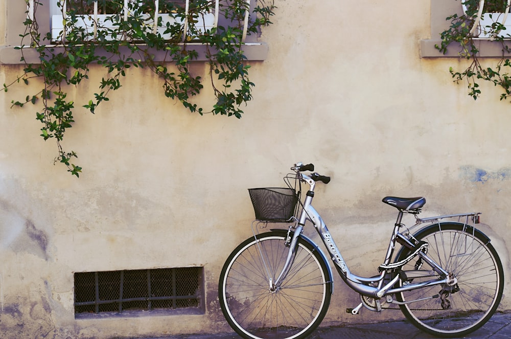 blue city bike parked beside green plants