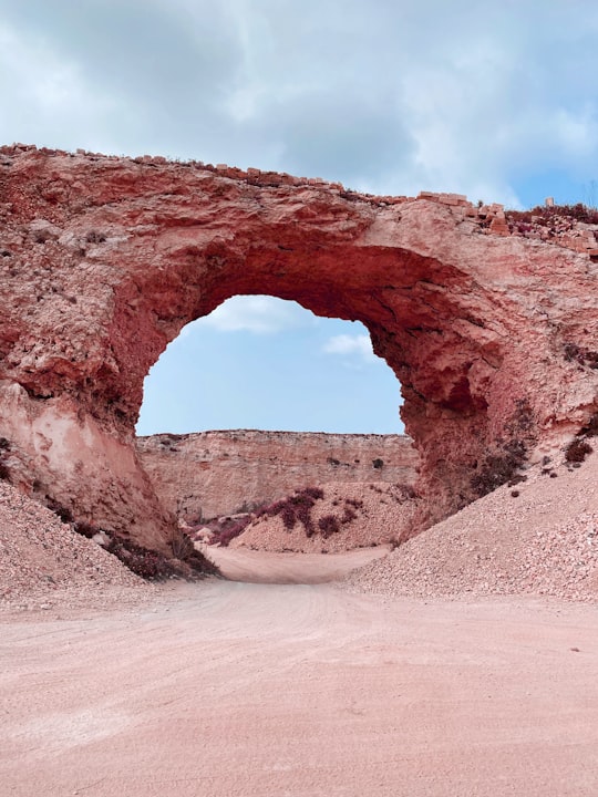 brown rock formation under white clouds during daytime in Gozo Malta