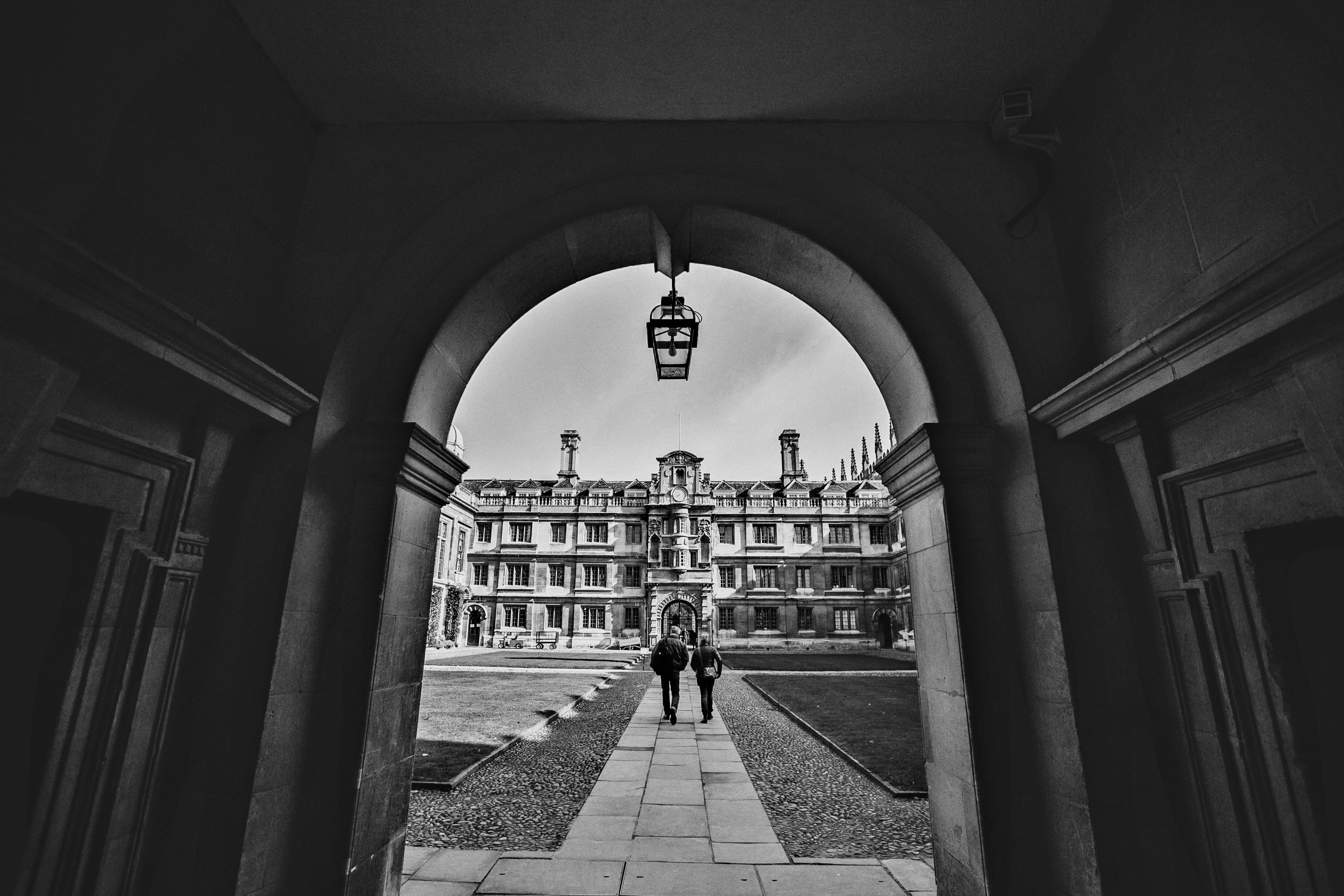 grayscale photo of people walking on sidewalk