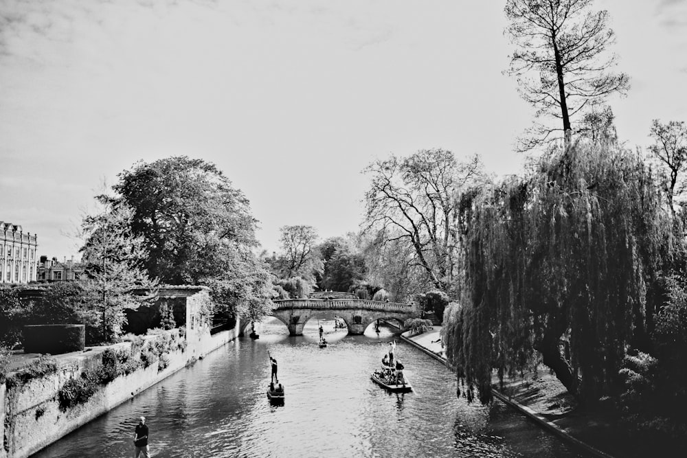 grayscale photo of people riding on boat on river