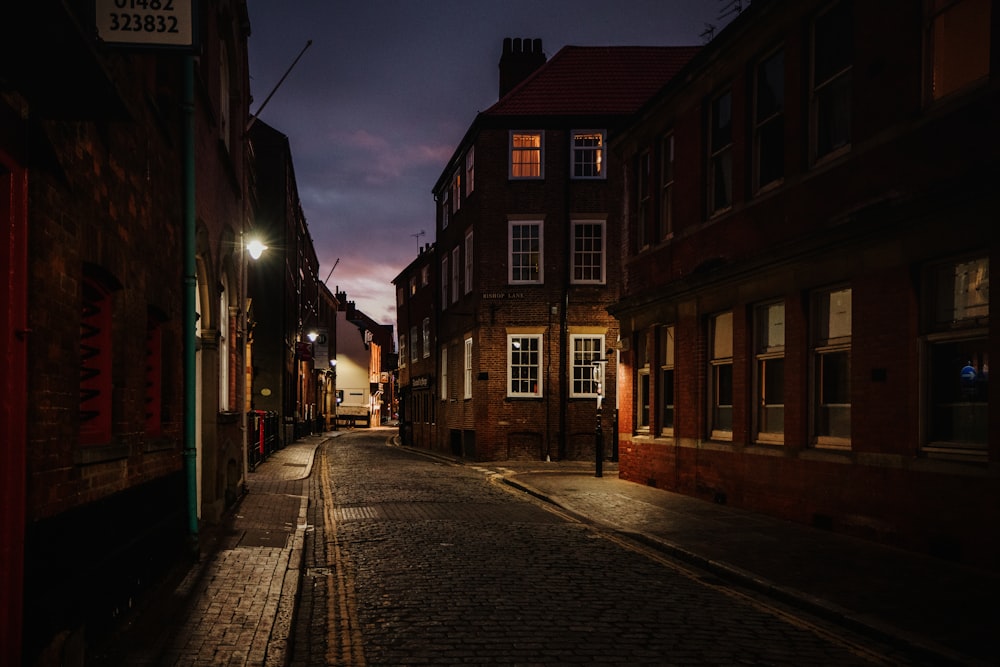 empty street in between buildings during night time