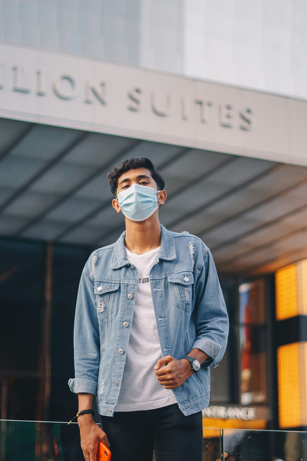 man in blue denim jacket wearing white mask