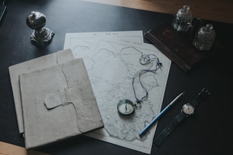 blue pencil beside white printer paper on brown wooden table